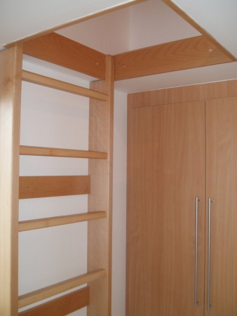 Vestavná skříň materiálově sjednocená se vstupem na galerii.